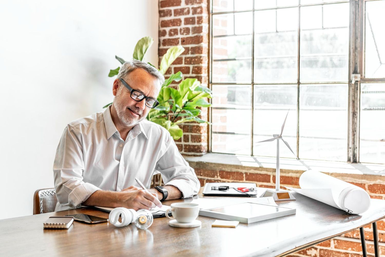 A healthcare worker and an older adult reviewing documents at a table. Both smiling.
