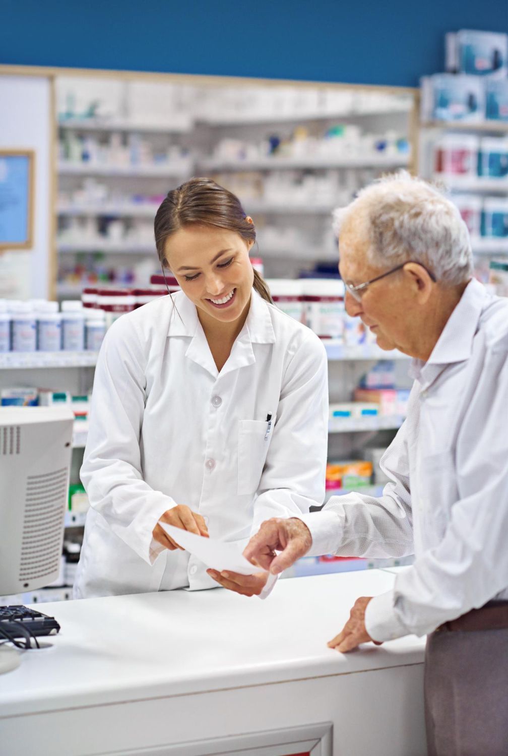 Hands stacked together with a healthcare provider in the background.