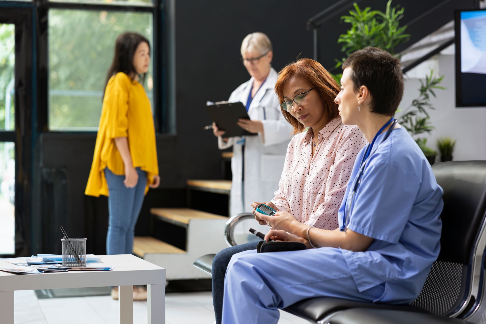 Hands stacked together with a healthcare provider in the background.