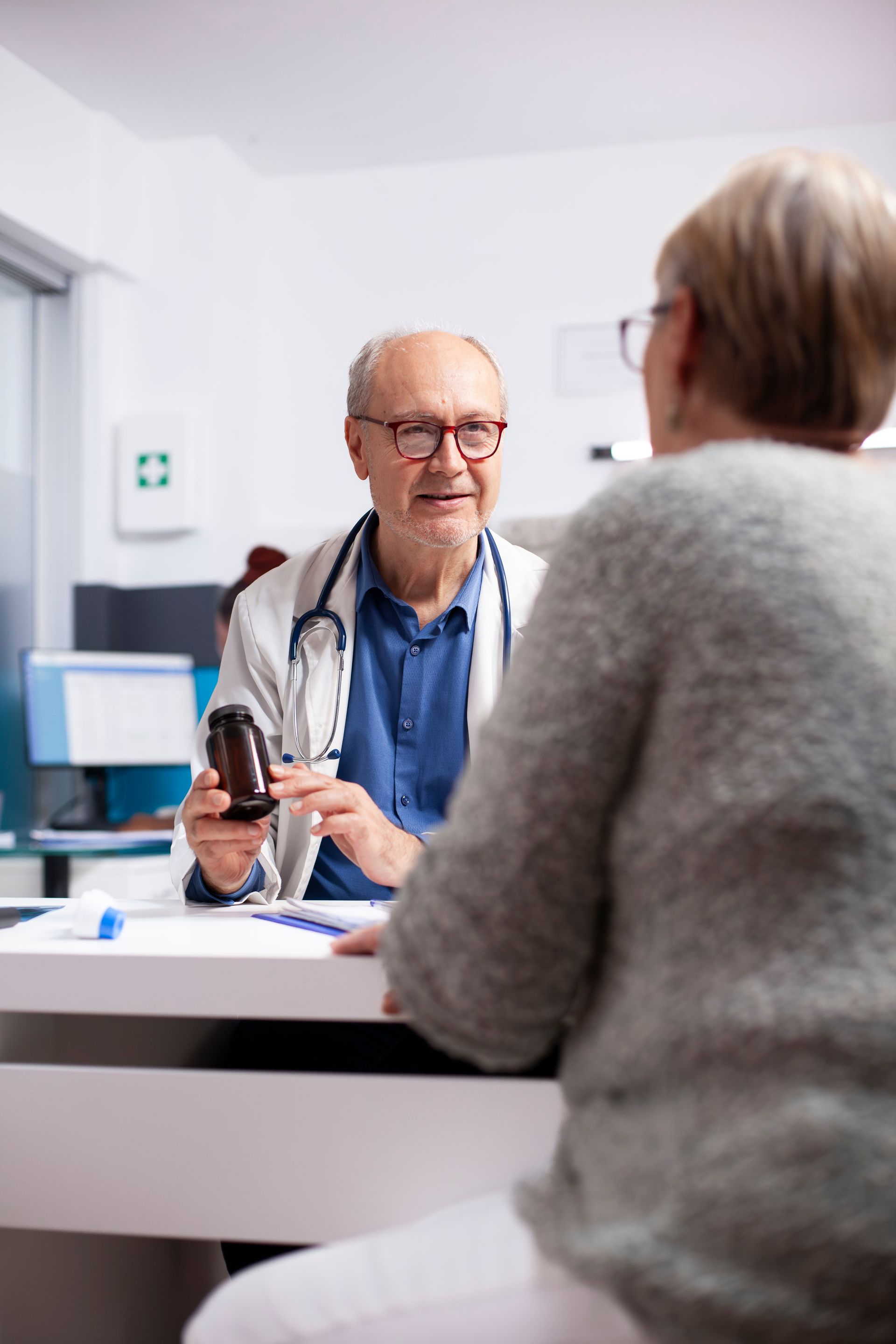 Grandparents and child walking hand-in-hand on a forest trail with wooden railing.