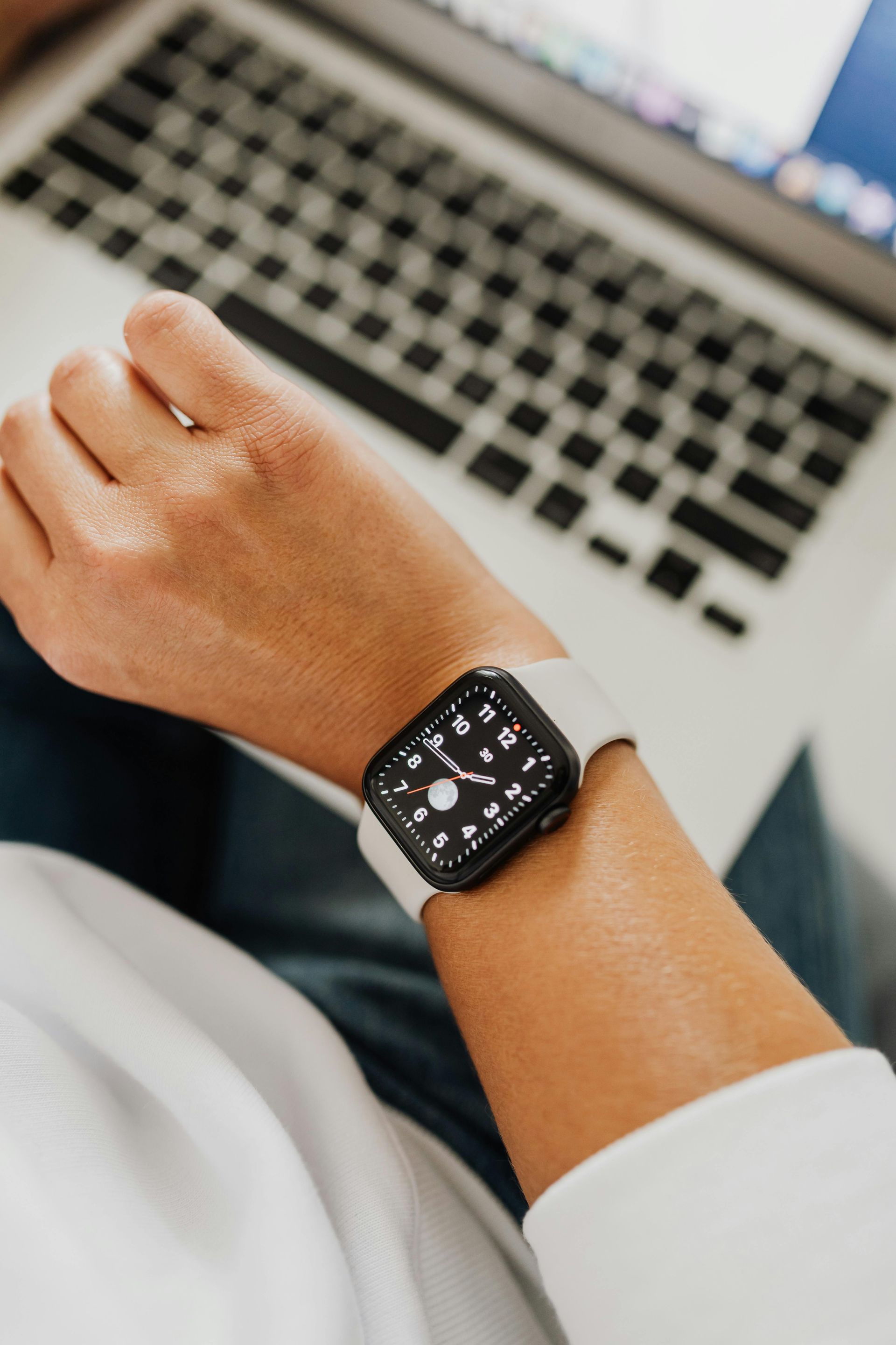 Hands stacked together with a healthcare provider in the background.