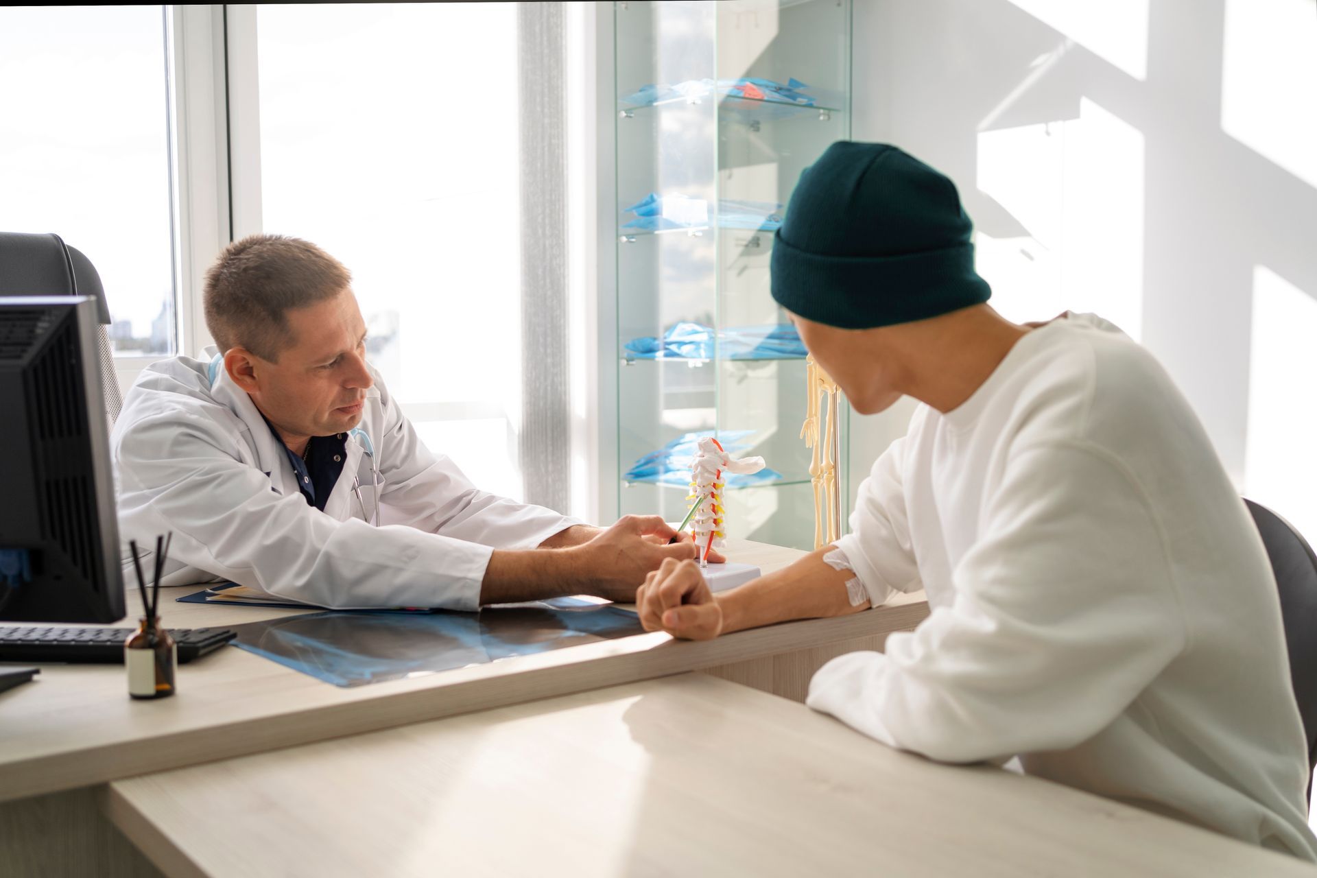 Hands stacked together with a healthcare provider in the background.