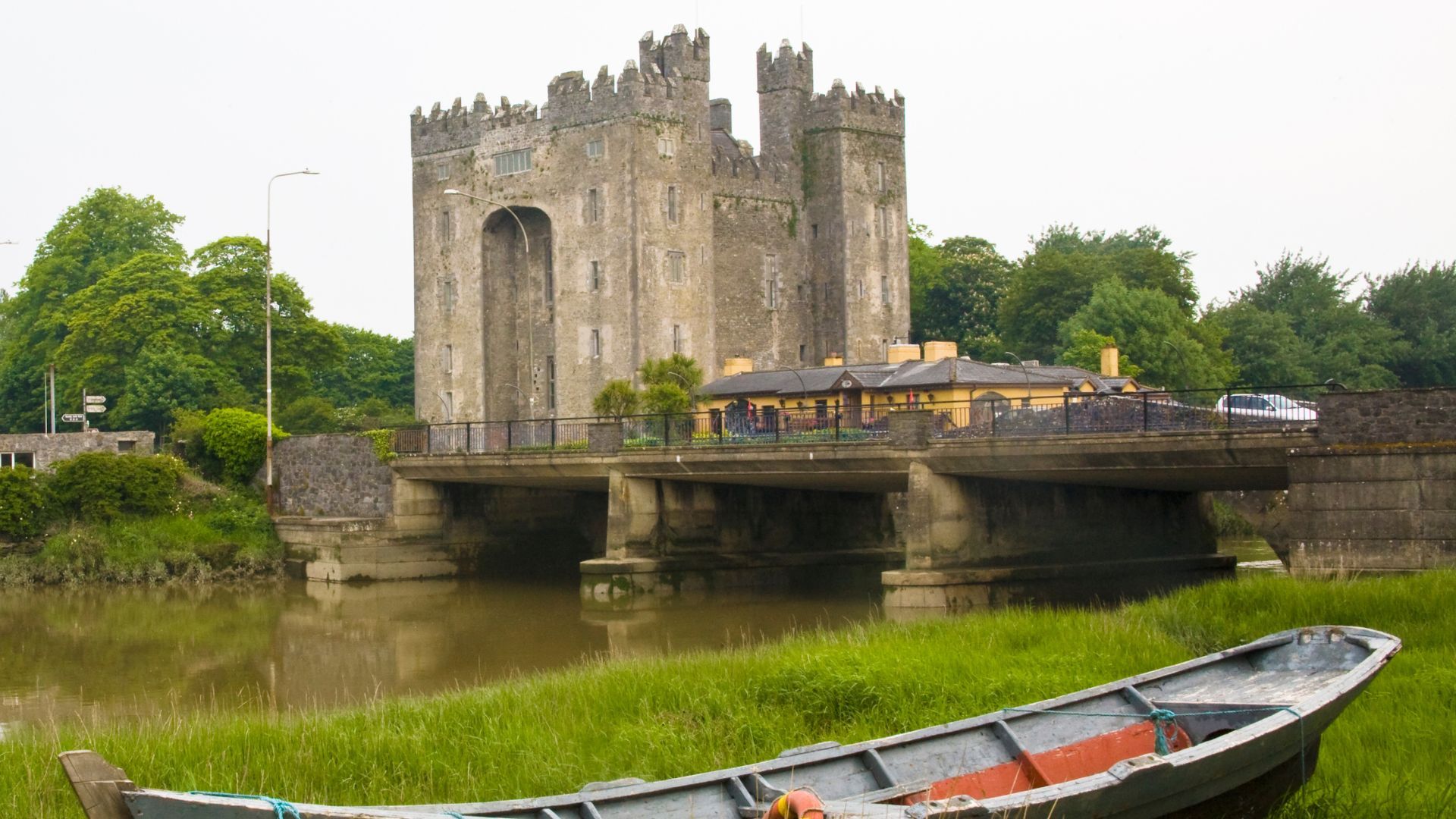 Stone castle with bridge and boat on river.