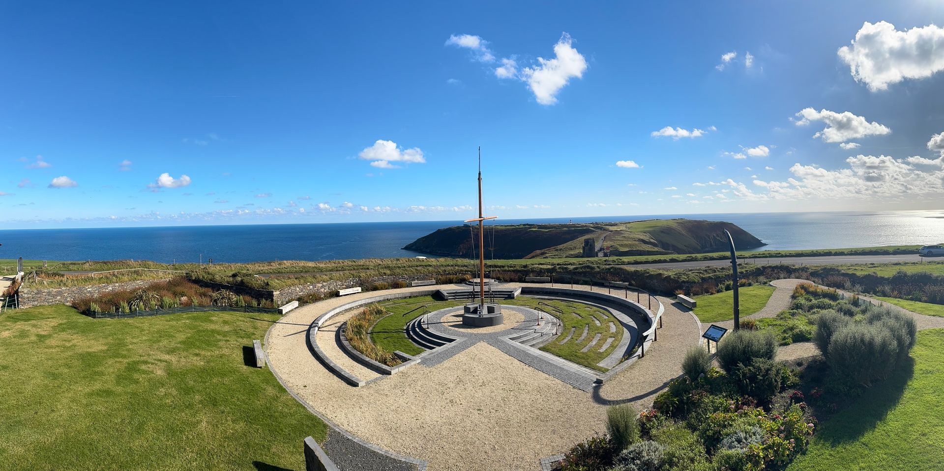 Stone circular garden by the sea under a blue sky with clouds