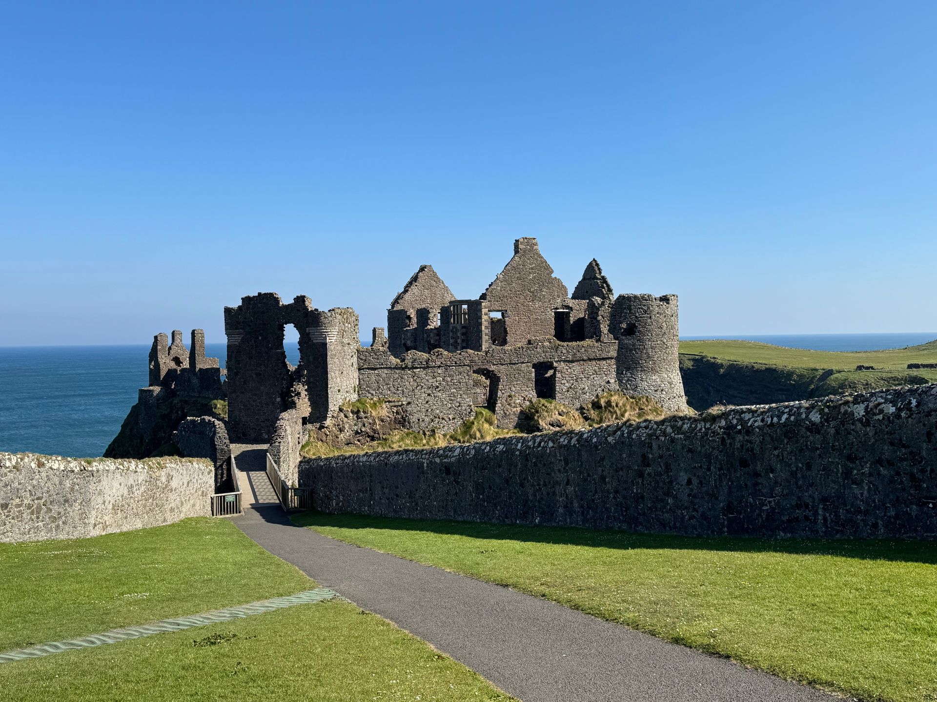 A castle is sitting on top of a hill overlooking the ocean.