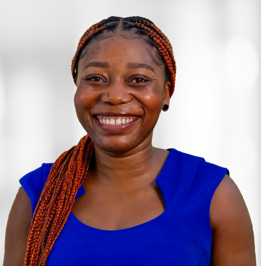 Smiling Black woman with braided orange hair, wearing a blue sleeveless top, against a blurred background.