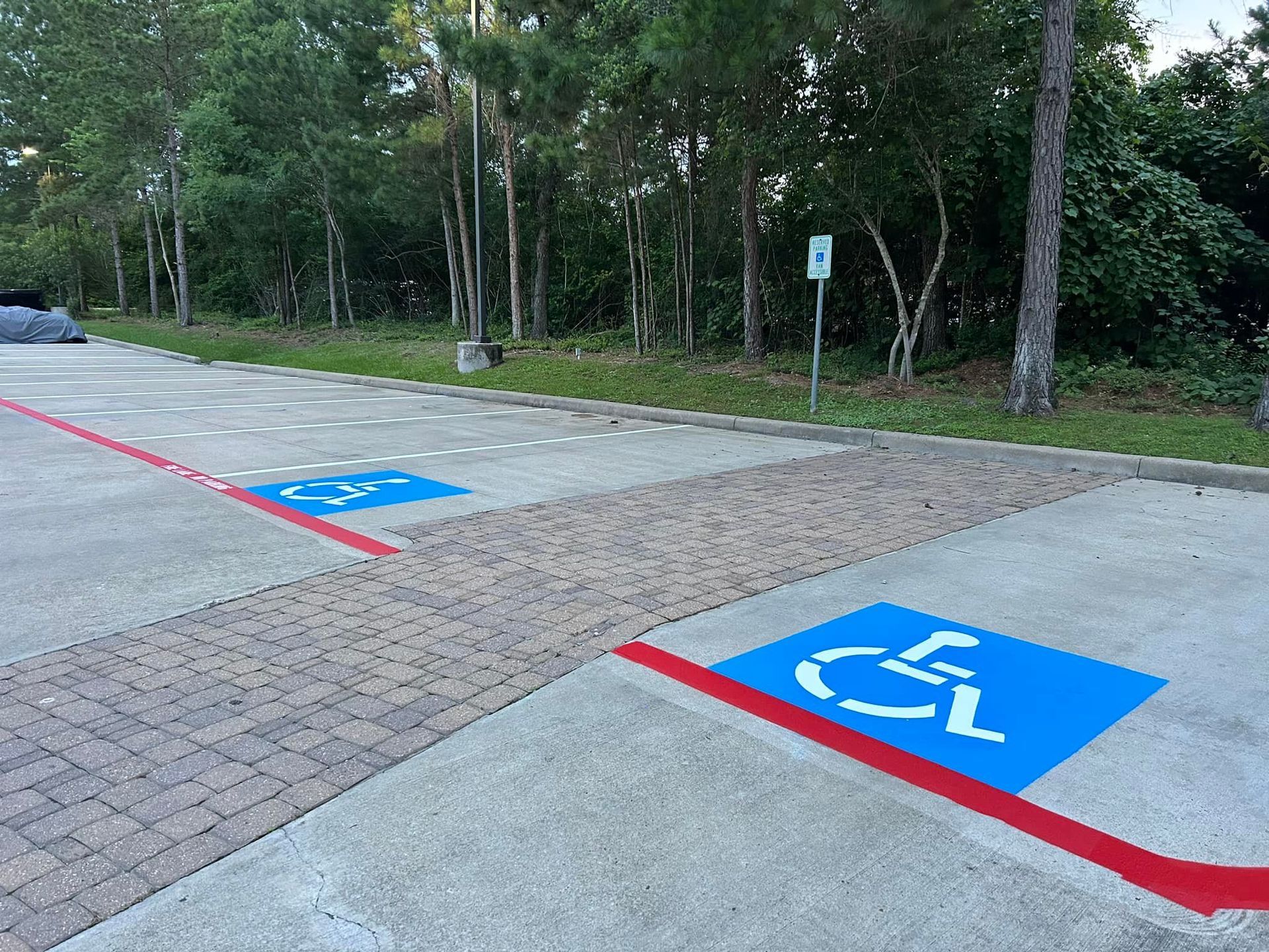 Handicap parking spaces marked with blue symbols and red lines in a parking lot.