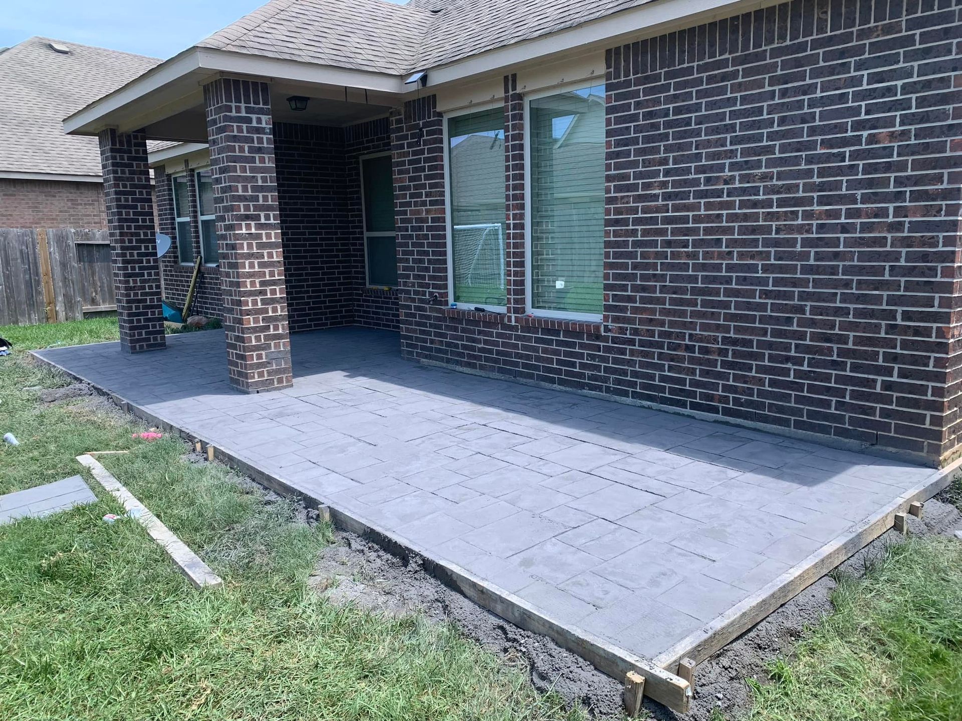 Brick home with a gray concrete patio and a grassy yard.