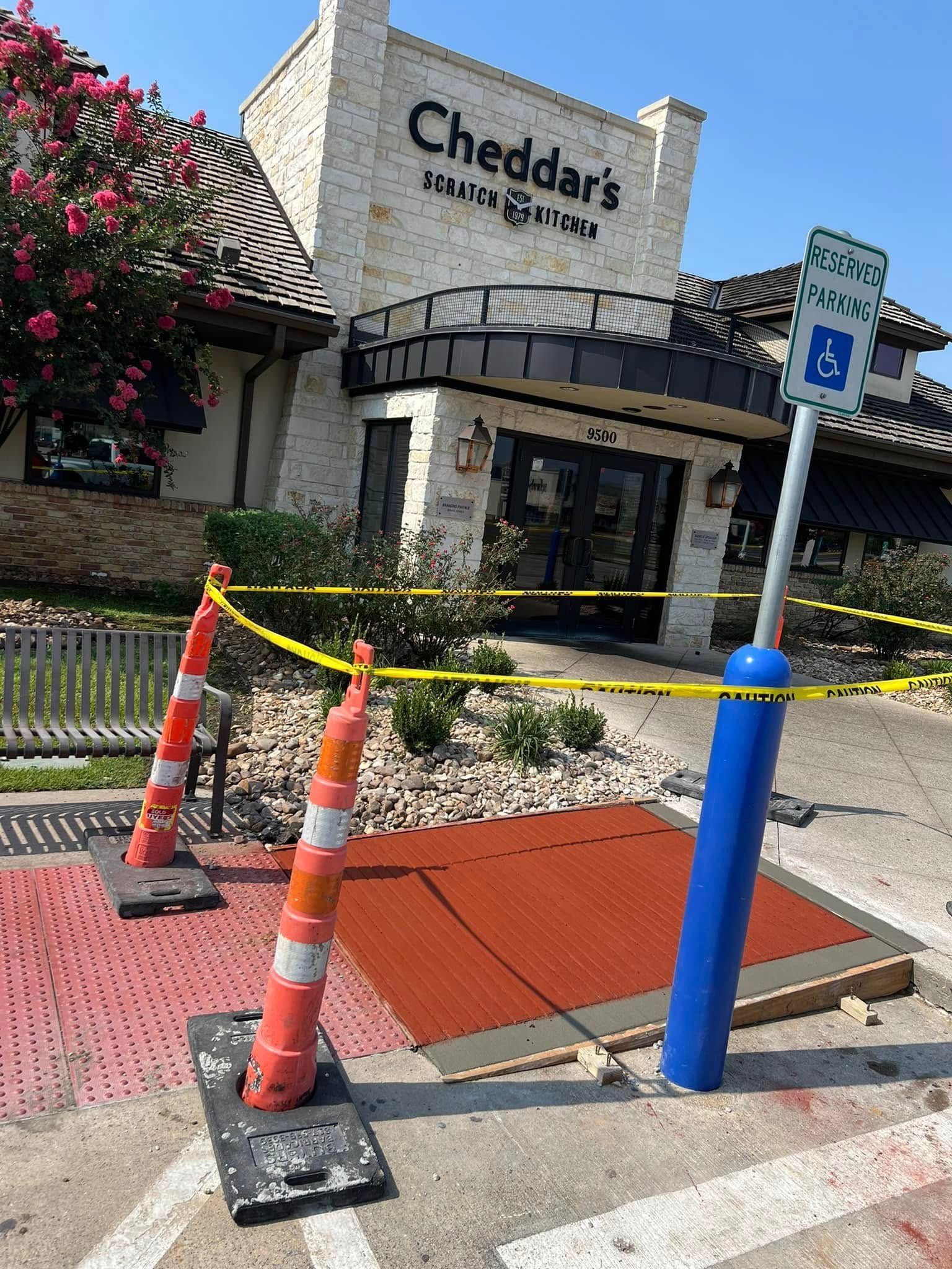 Exterior view of Cheddar's Scratch Kitchen with construction barricades in front of the entrance.