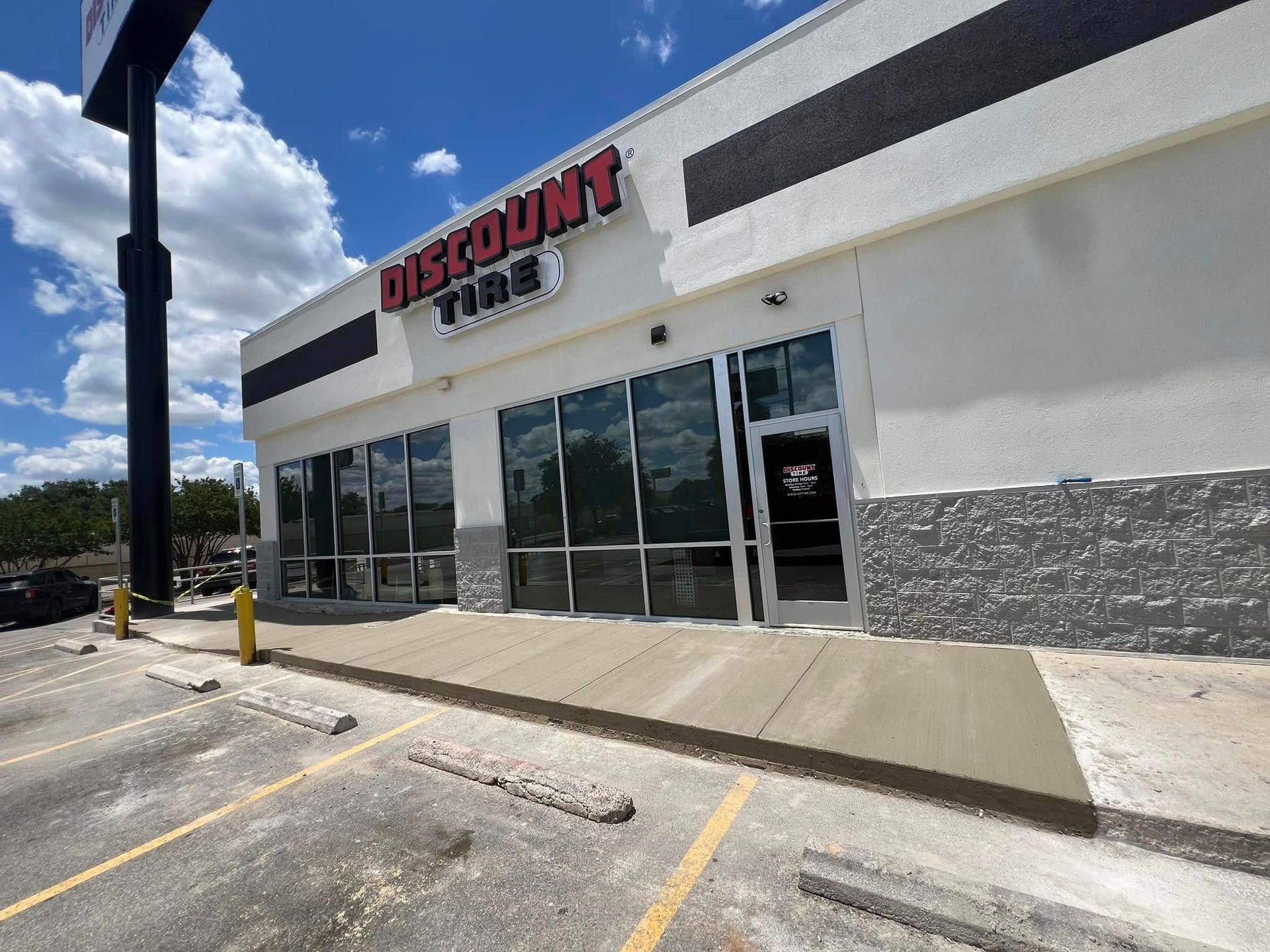 Discount Tire store exterior with a blue sky, and parking lot.