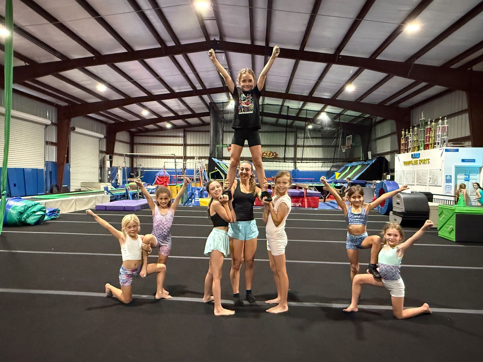 A group of young girls are posing for a picture in a gym.