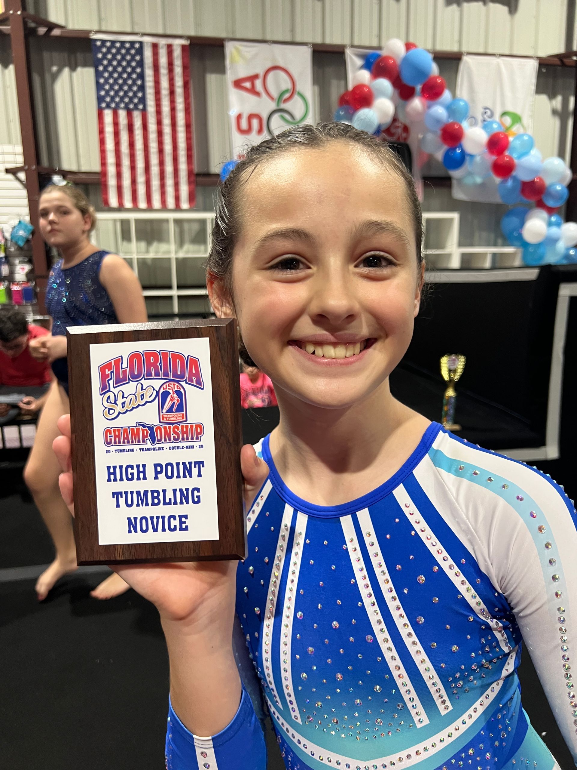 A young girl is holding a plaque that says high point