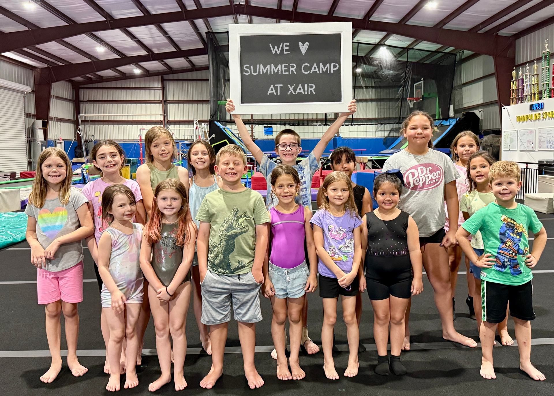 A group of children are posing for a picture in a gym.