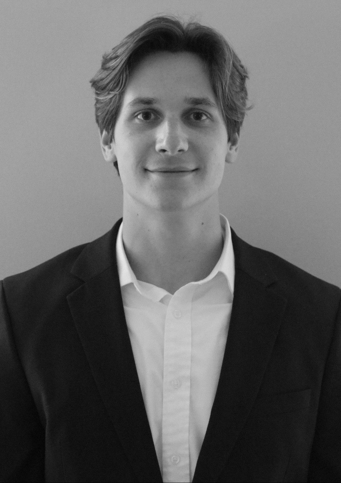 A woman with blonde hair is smiling and wearing a white shirt