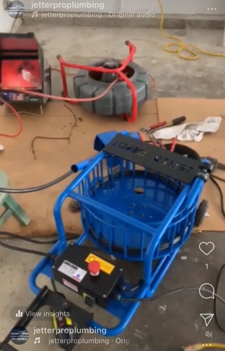 A blue machine with a red button on it is sitting on a table