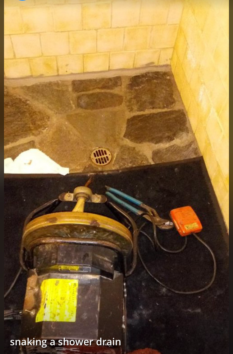 A picture of a shower drain that is being repaired