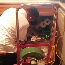 Luciano Snaking a Bathroom Drain A man is working on a drain under a sink.