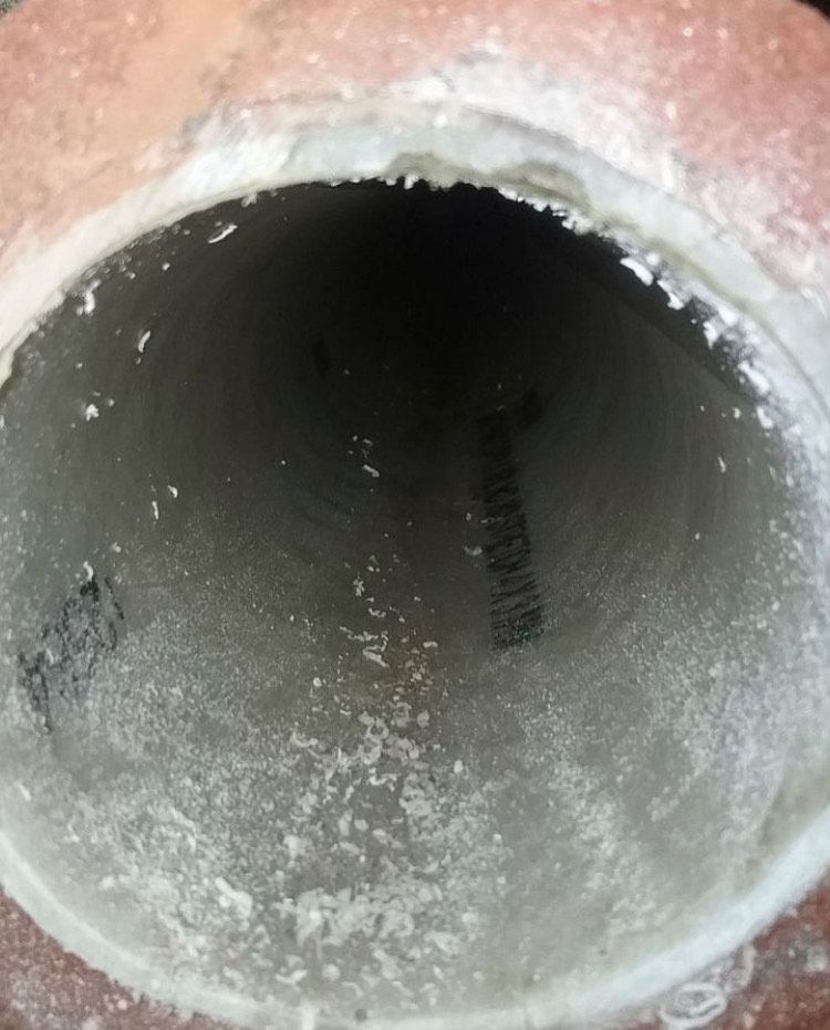 A close up of a dirty pipe with a hole in the middle