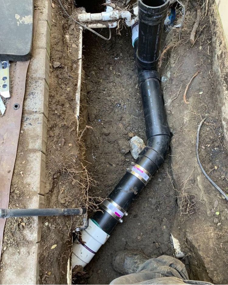 A drain pipe is being installed in a hole in the ground.