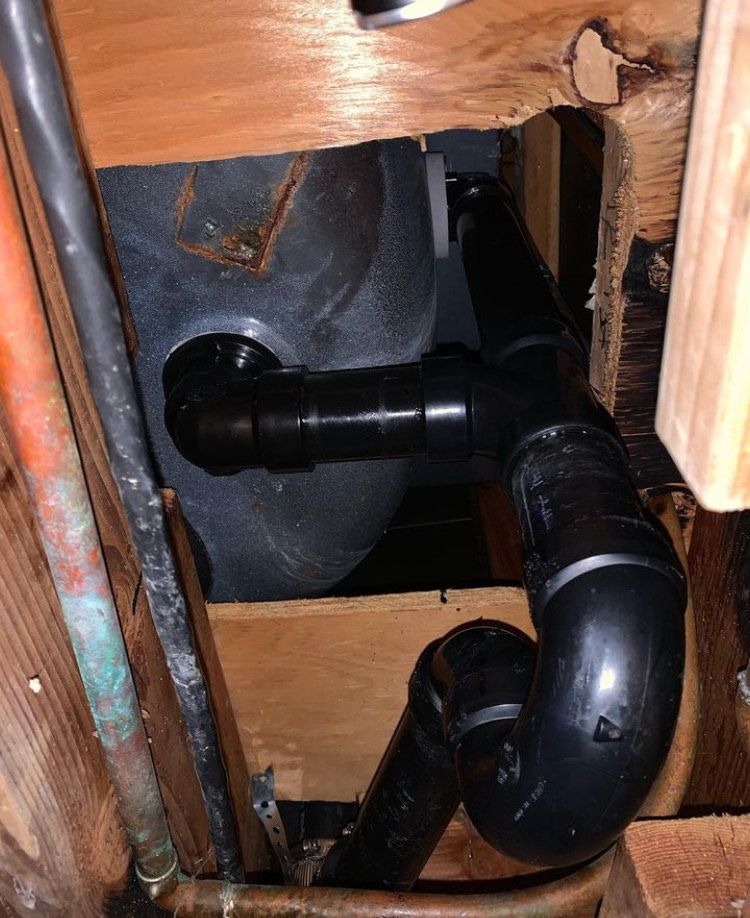 A bunch of pipes are connected to a wooden wall.