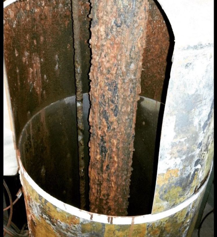 A rusty metal pipe with a white stripe around it
