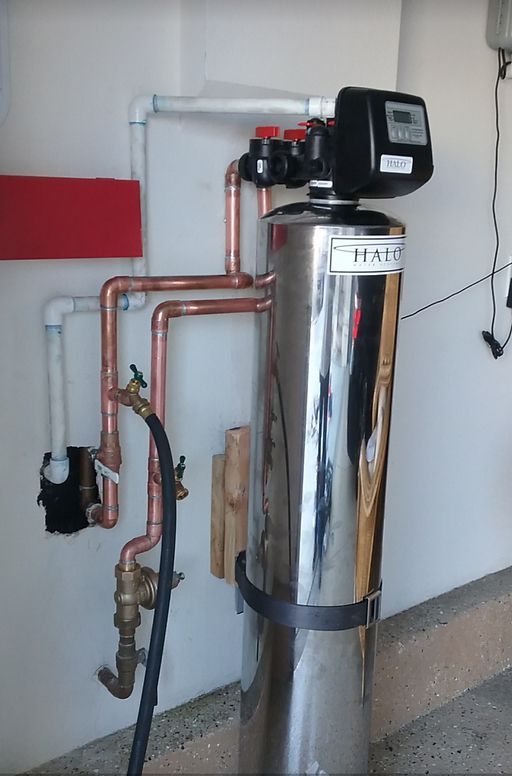 A stainless steel water filter with copper pipes attached to it