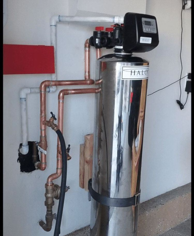 A stainless steel water filter with copper pipes attached to it