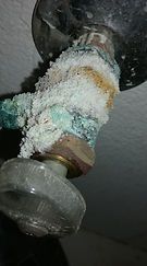 A close up of a faucet with a lot of soap coming out of it.
