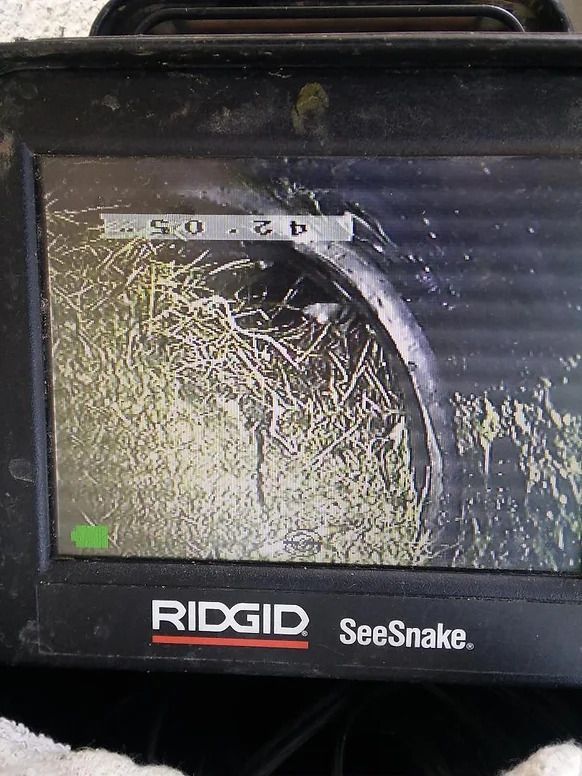 A ridgid seesnake camera shows a snake in a pipe.