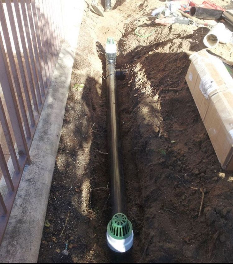 A drain pipe is being installed in the dirt