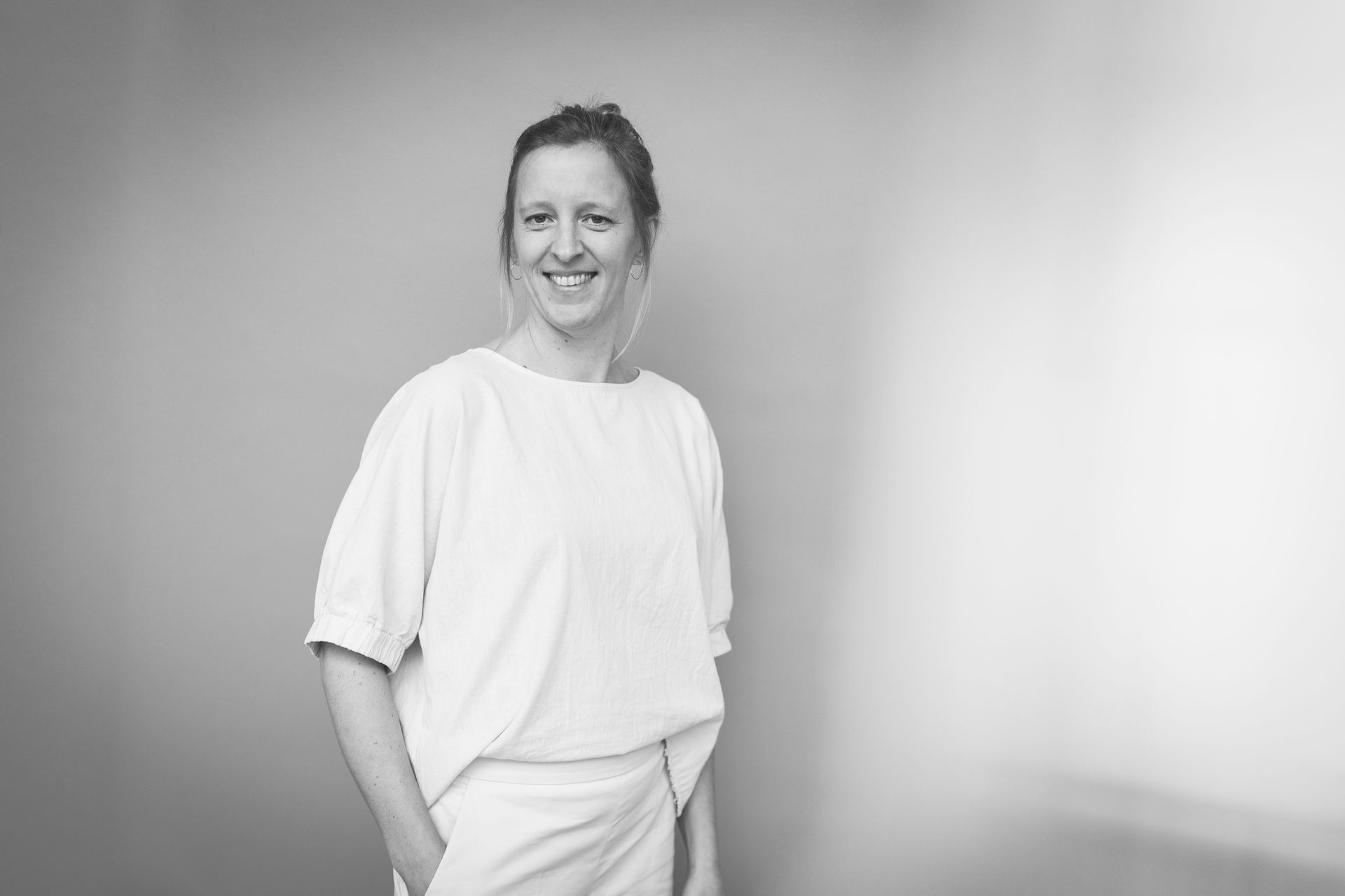 Profilbild von Lea vor dem orangenen Hintergrund – sie lächelt.