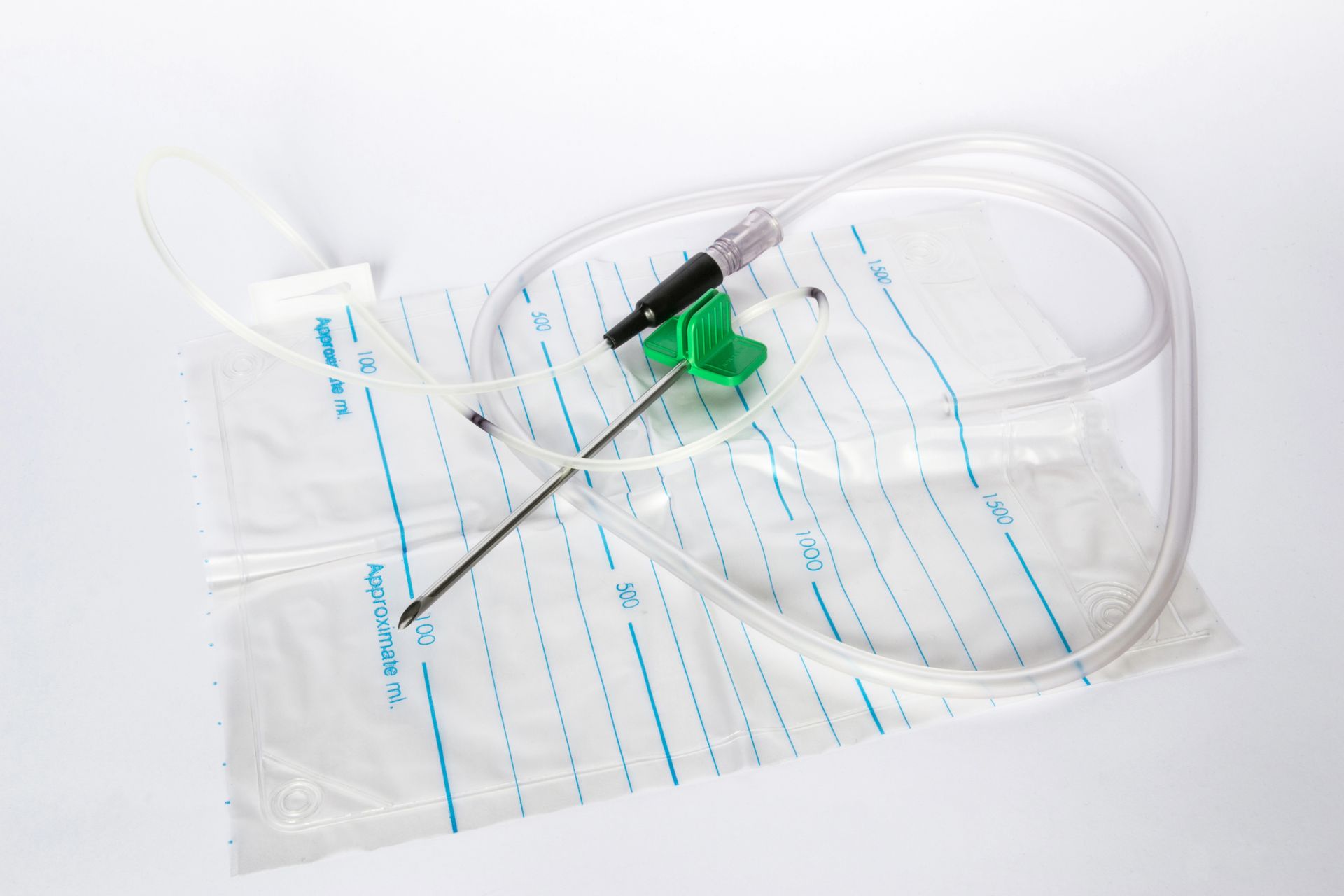 Medical equipment: catheter with needle and collection bag on a white surface.