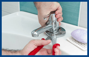 man with a wrench fixing a sink tap