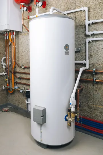 White water heater mounted on a wall, connected to power and water pipes.