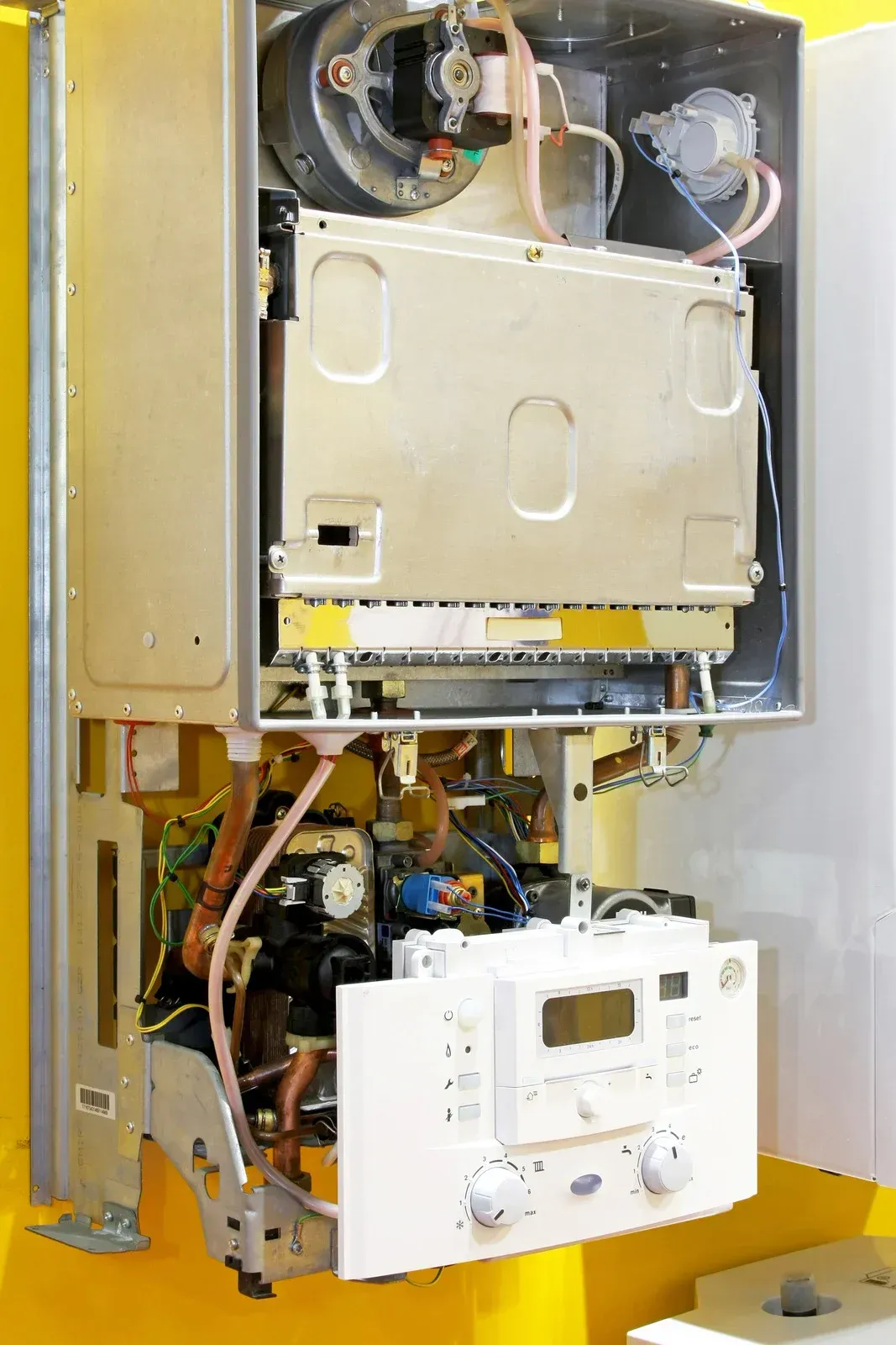 Open view of a wall-mounted gas boiler, showcasing internal components and control panel.