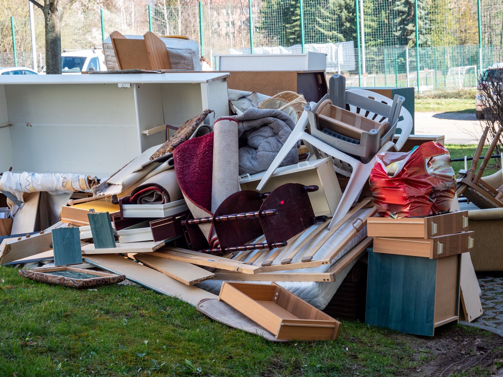 A pile of junk is sitting on top of a lush green field.