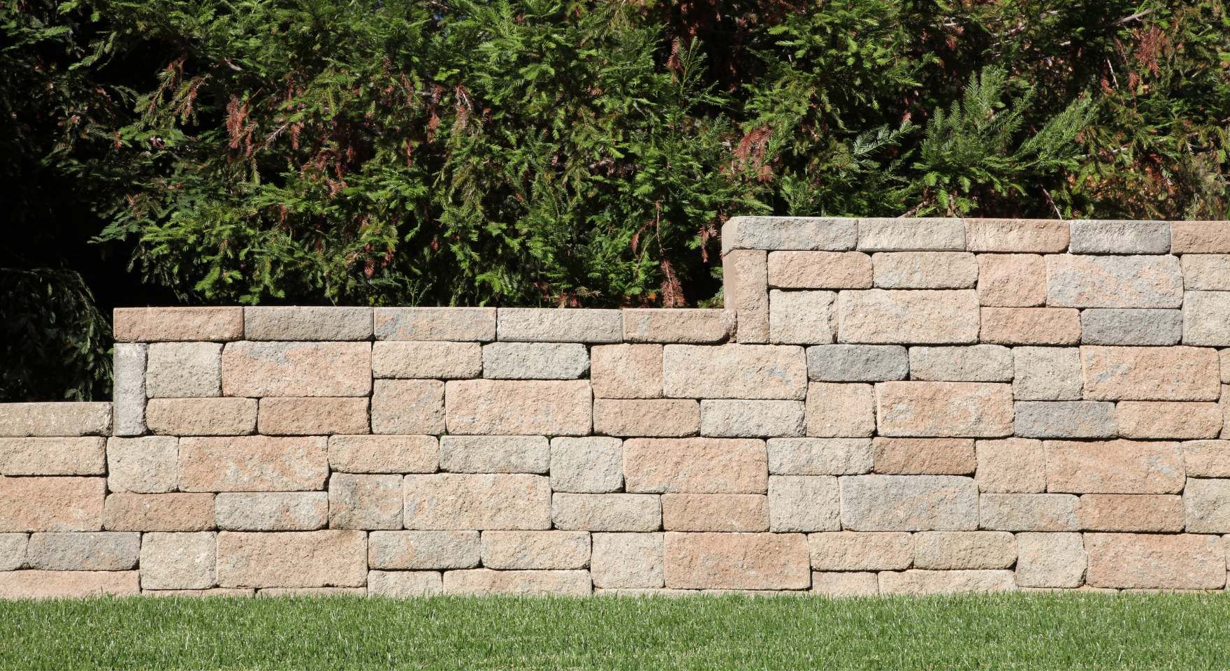 Short concrete block retaining wall built along a landscaped slope in Huntington Beach, CA