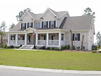 A large white house with black shutters and a large porch