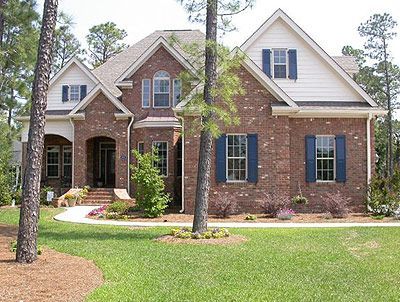 A large brick house with blue shutters on the windows