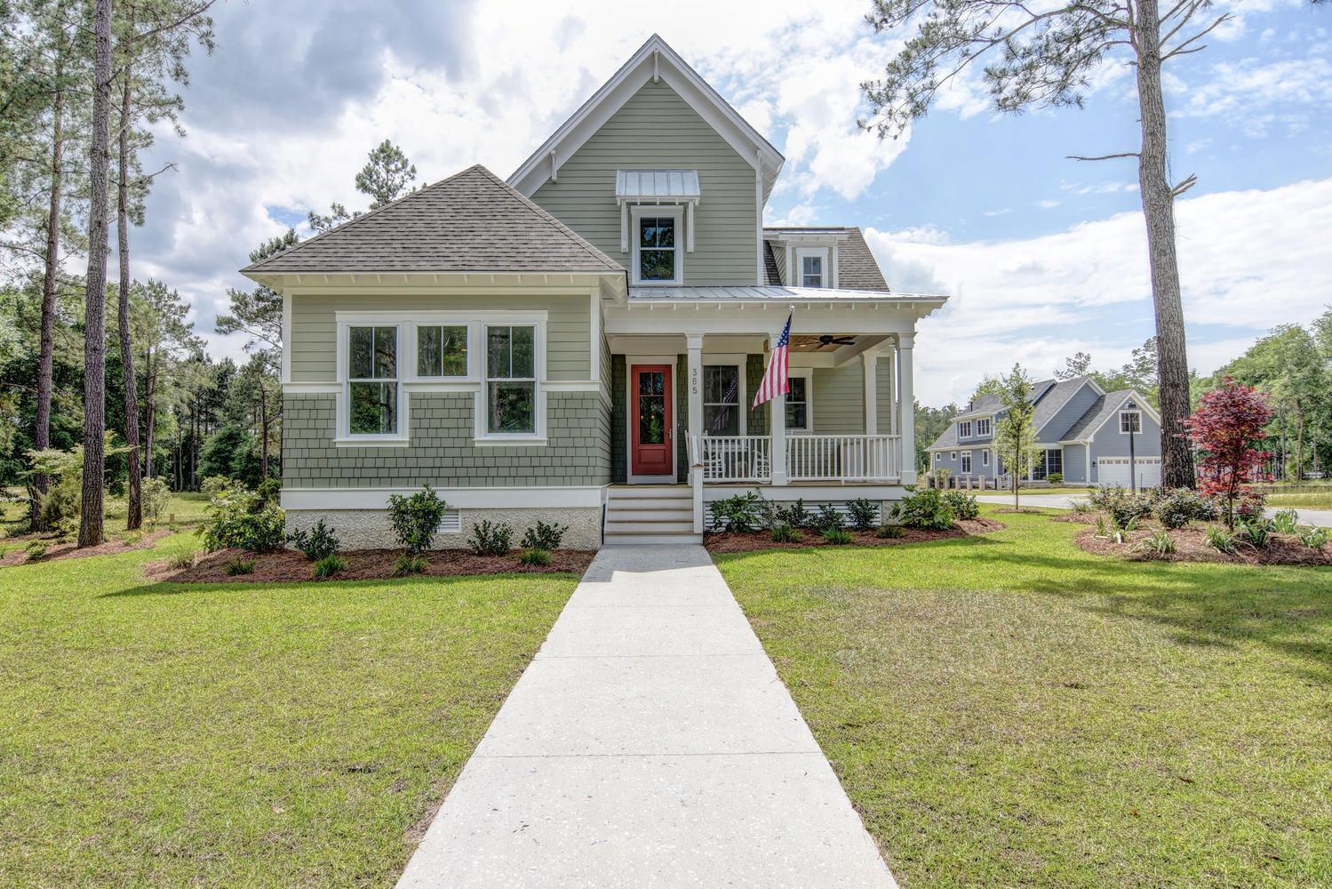 The front of a house with a red door and a walkway leading to it.