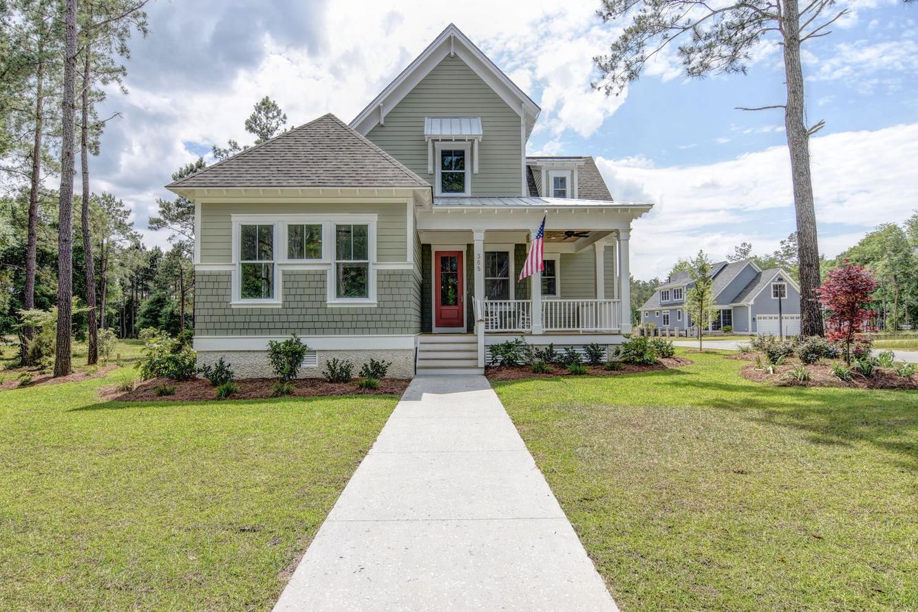 The front of a house with a red door and a walkway leading to it.