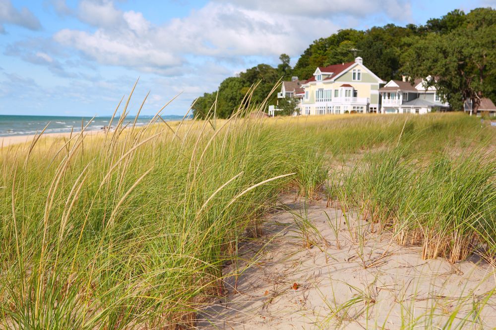 A house is sitting on top of a hill next to a beach.