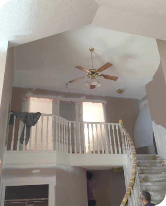 A room with a balcony and a ceiling fan