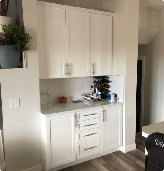 A kitchen with white cabinets and a wine rack