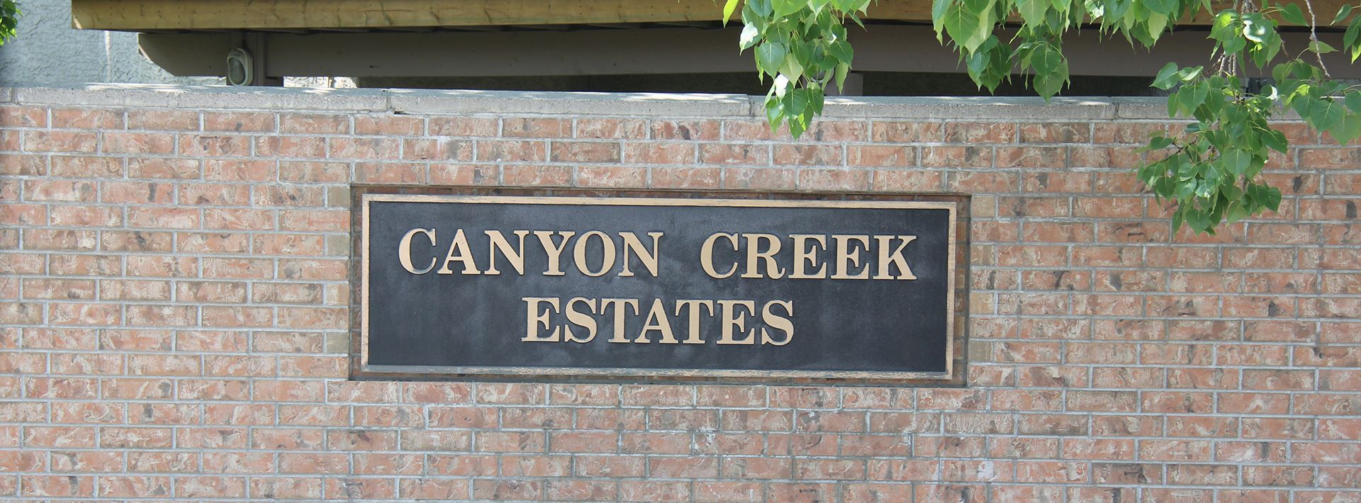 A Canyon creek estates sign on a brick wall
