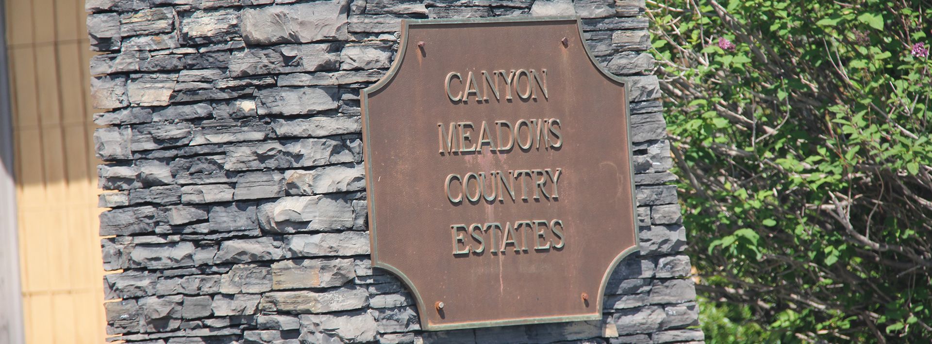A sign on a stone wall that says Cannon meadows country estates