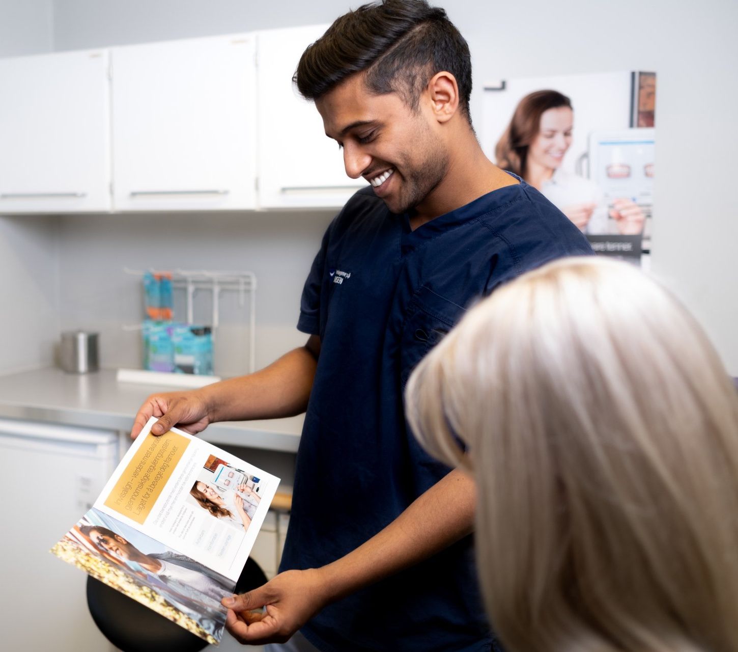 Tannlege Neddersan viser en bok til en pasient