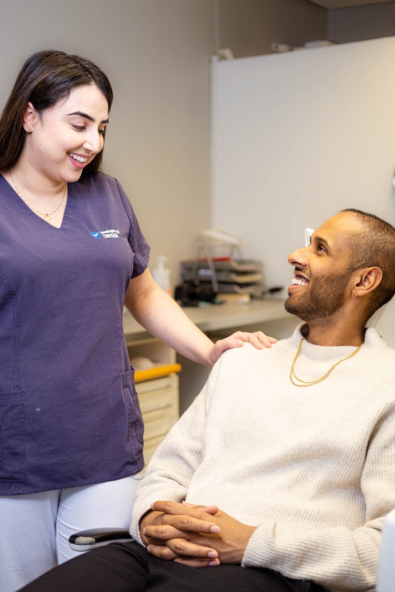 Tannlege Amrit smiler til en pasient hos Tannlegene på Sinsen