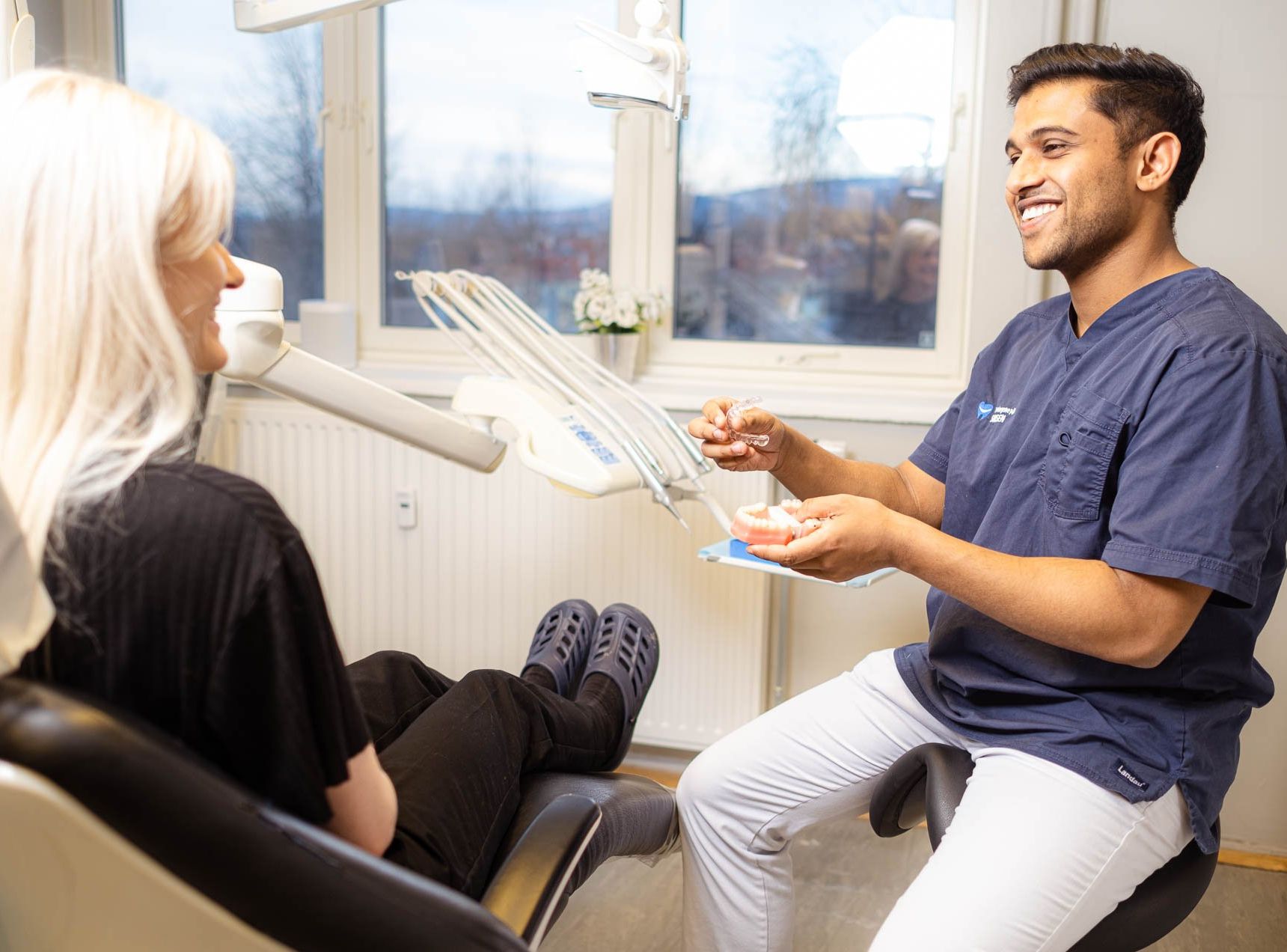 Tannlege Nedd presenterer usynlig tannregulering løsning for pasient.