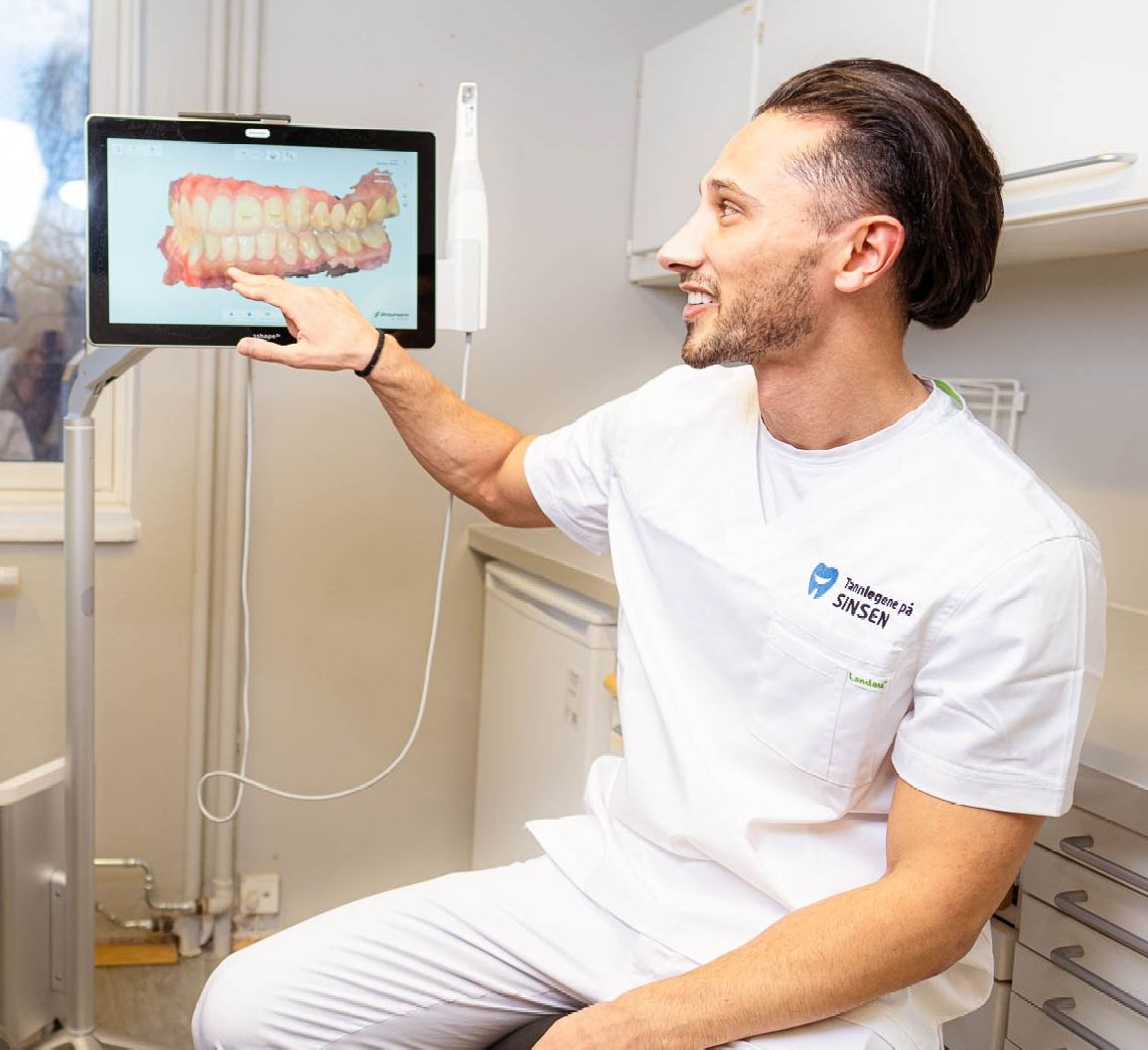 Tannlege Omar viser en tannkrone på scanneren
